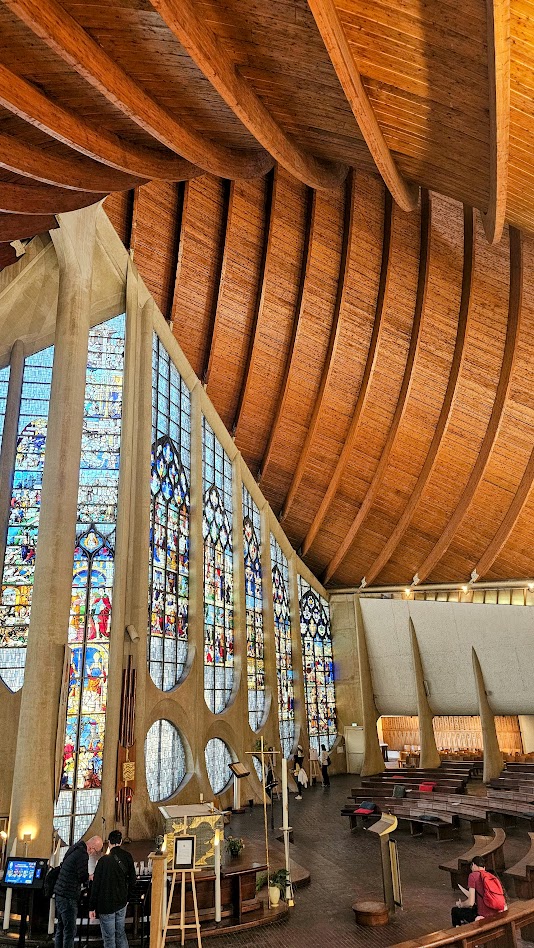 Interior da Igreja de Santa Joana d'Arc em Rouen com vitrais históricos.