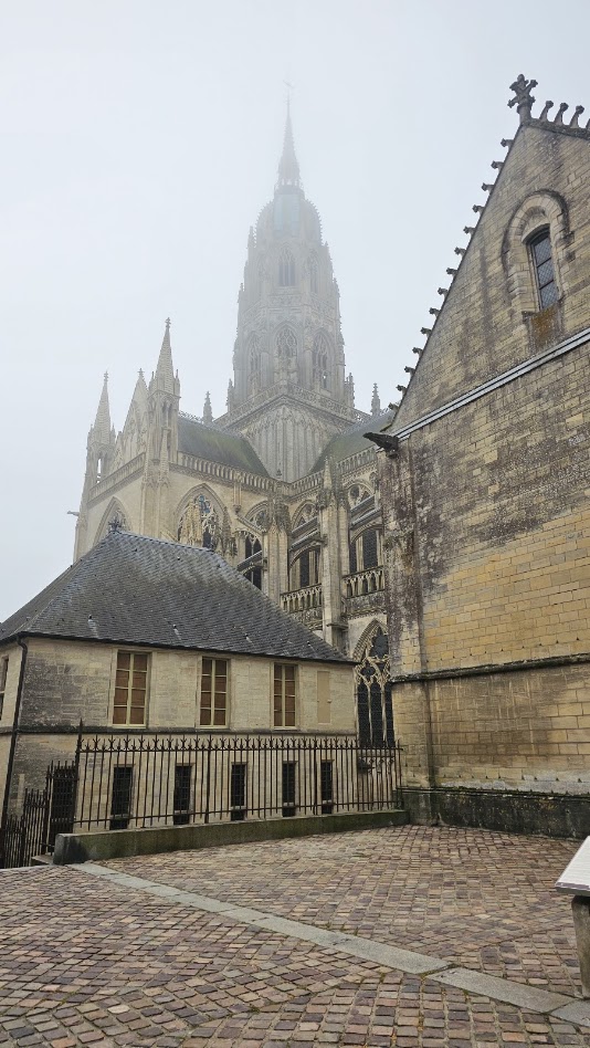 Catedral de Notre-Dame de Bayeux envolta em nevoeiro, vista entre as ruas do centro histórico