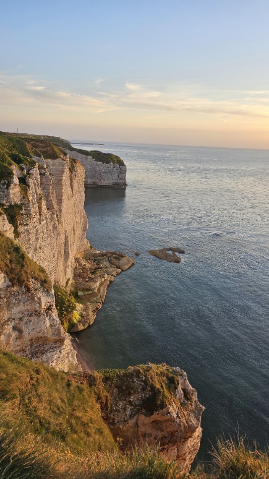 Vista das falésias de Étretat ao pôr do sol, junto à Manneporte, na Costa de Alabastro, Normandia.